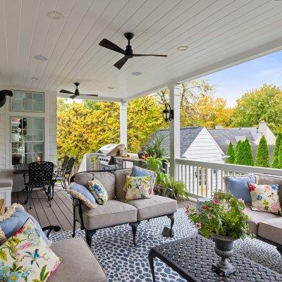 covered outdoor living space with ceiling fans, TV, grilling area black metal furniture