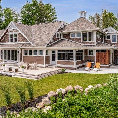 exterior view from lake: outdoor shower, screened porch, library